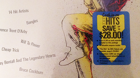 Closeup of a coupon sticker on the LP version of the Hits